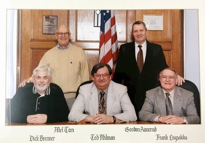 Five male commissioners sitting for camera